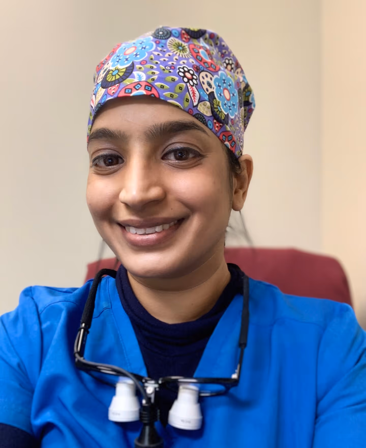 Dr. Nadia Shaikh smiling, in blue scrubs and a patterned scrub cap.